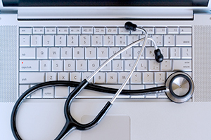 laptop with stetheoscope draped over it - doctorgeek logo
