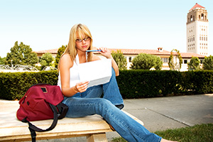 female student reading on campus